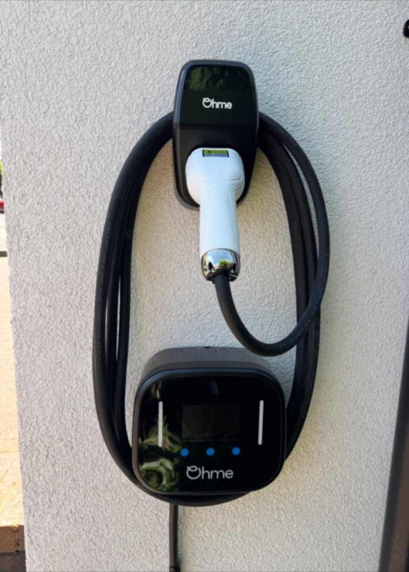 Ohme EV charge point installed on a rendered wall in Pinner.