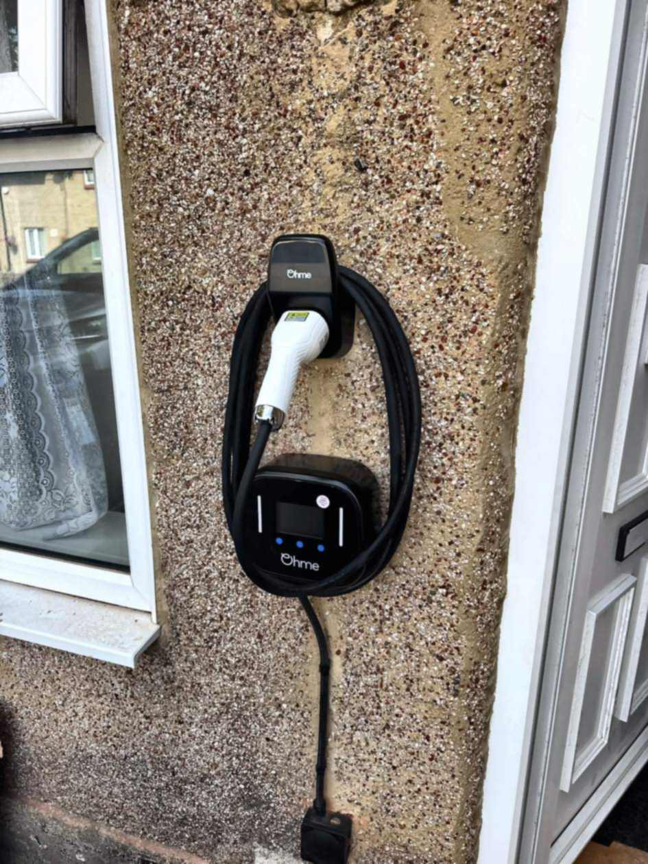 Wider view of the Ohme installation in West Drayton, mounted between the front window and door with the supply cable dropping to a junction box below.